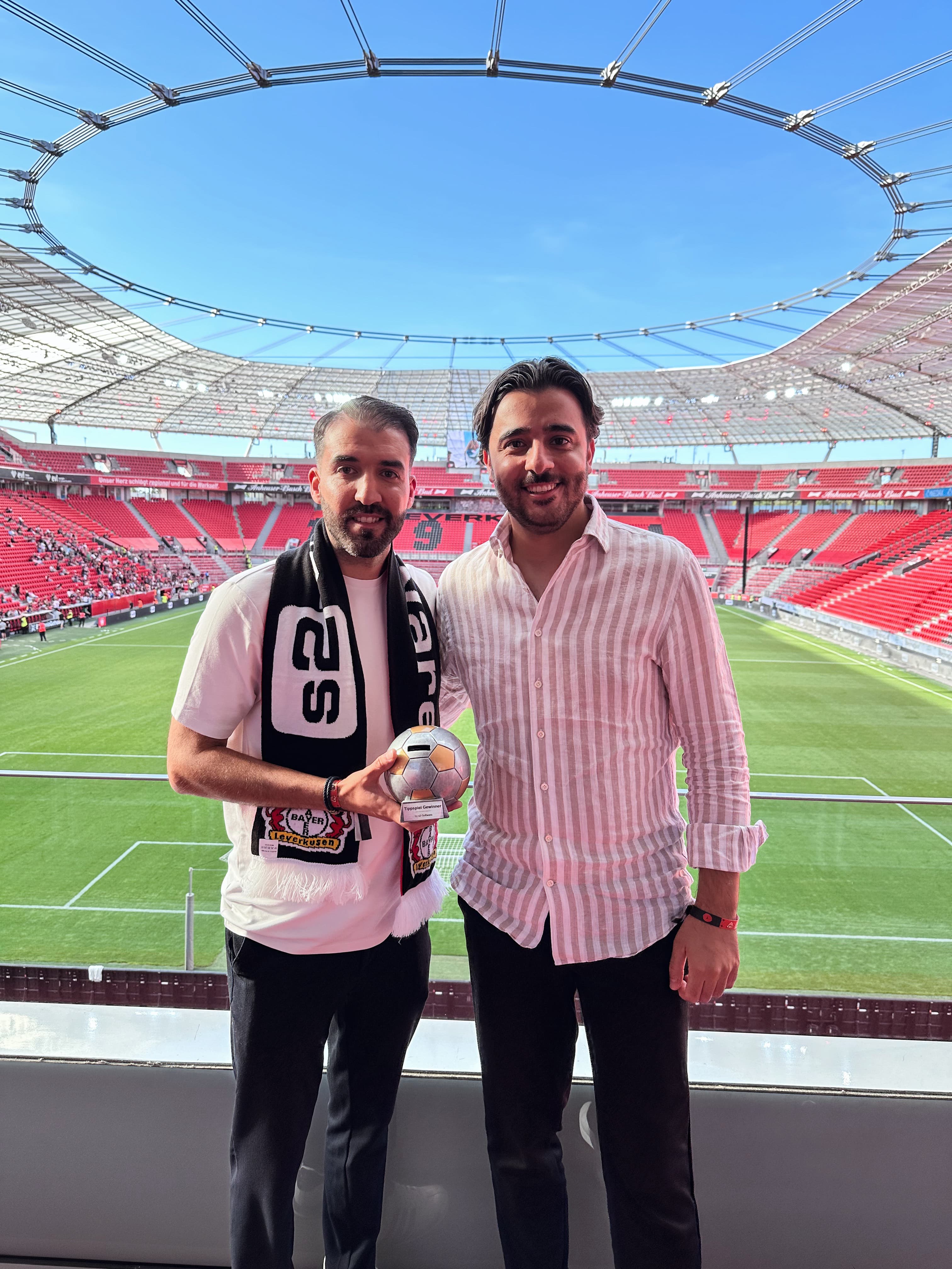Gäste in der Loge mit Tippspiel-Pokal